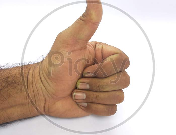 Closeup Of Male Hand Showing Thumbs Up Sign Against White Background