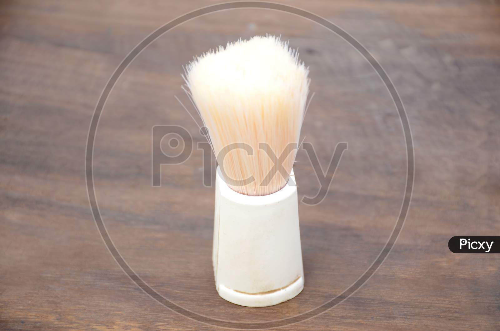 The White Color Saving Brush On The Wooden Background.