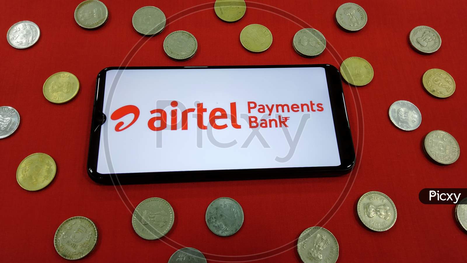 Tamilnadu, India- February 15 2021:Indian currency along with Airtel payments bank logo on a smart phone