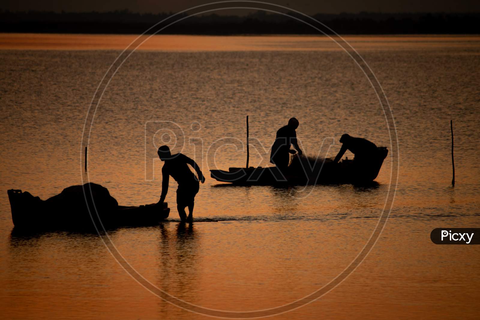Silhouette View Of The Fishermen With There Boats In Odiyur Lake Along The East Coast Road During Sunset, Tamil Nadu, India. Selective Focus