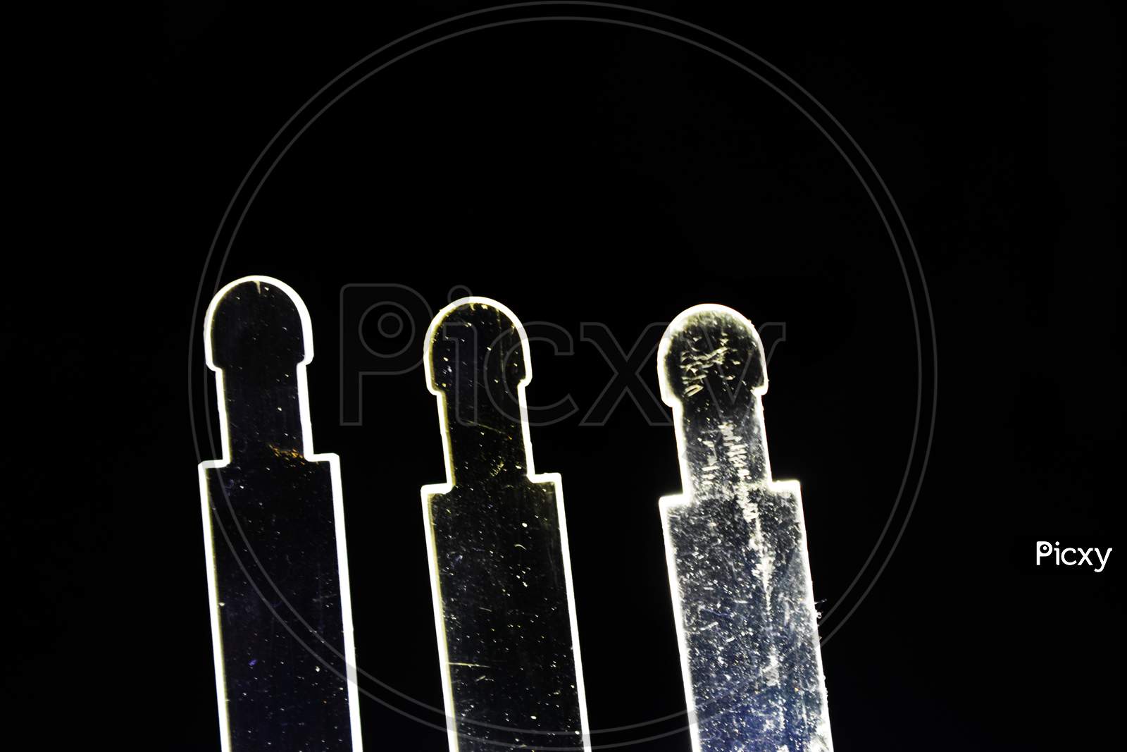 Three Transparent Glass Structure Outlined By Lights In A Black Background