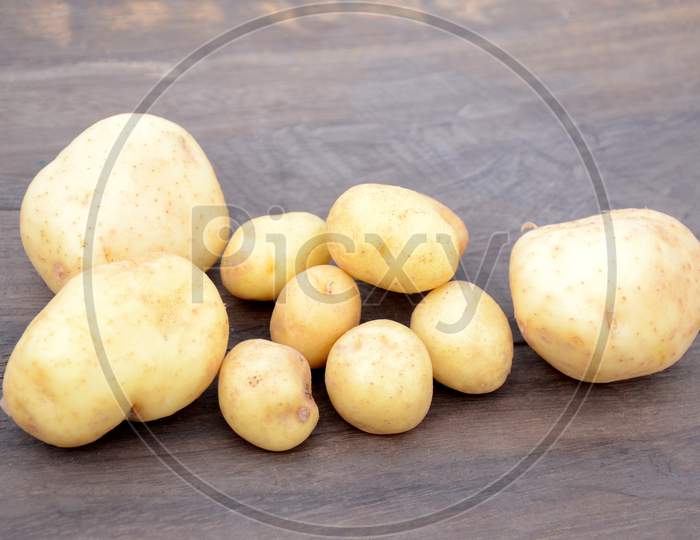 Bunch The Fresh Ripe Potato On The Wooden Background.
