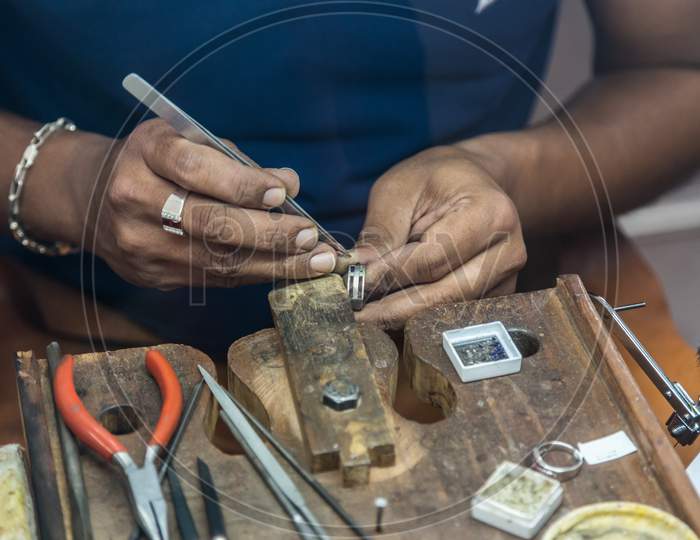 Jeweler Making Handmade Jewelry On Vintage Workbench.