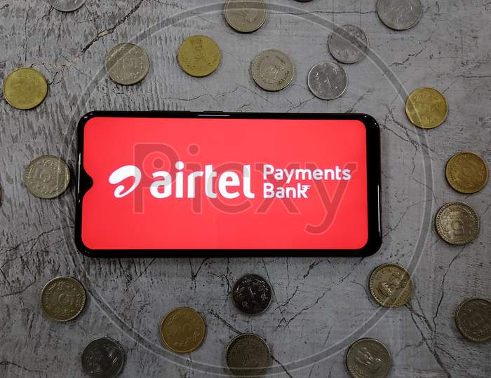 Tamilnadu, India- February 15 2021:Indian currency along with Airtel payments bank logo on a smart phone