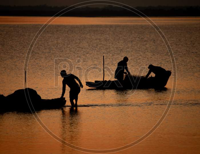 Silhouette View Of The Fishermen With There Boats In Odiyur Lake Along The East Coast Road During Sunset, Tamil Nadu, India. Selective Focus