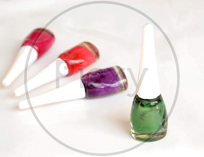 The Colorful Nail Paint Glass With Plastic Bottle Isolated On White Background.
