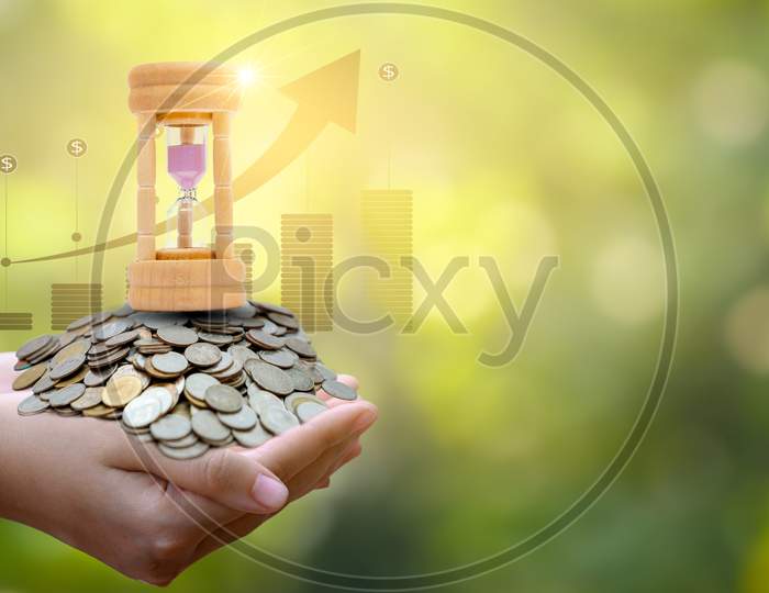 Silver Coins And Hourglass And Financial Business Concepts And Use Of Time