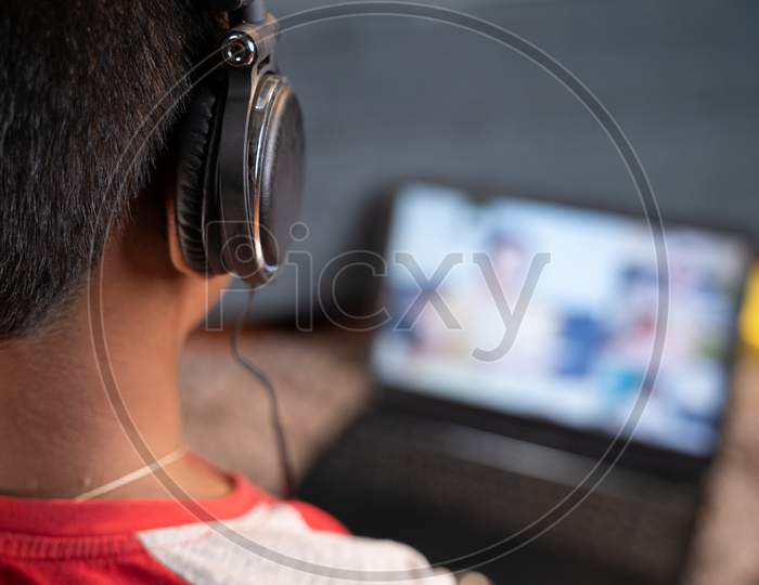 Shoulder Shot Teenager Kid With Headphone Listening Online Class - Concept Of Online Virtual Education, New Normal And Homeschooling Due To Coronavirus Covid-19 Pandemic.