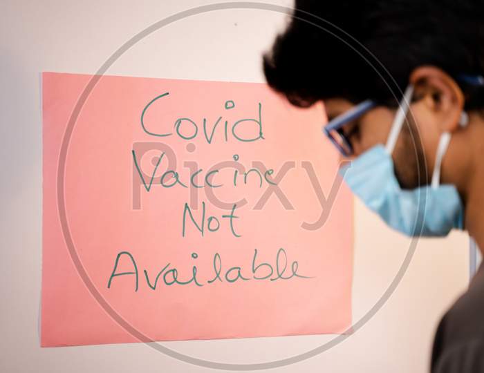 Selective Focus On Notice Board,Young Man Got Worried After Looking Covid-19 Vaccine Not Available Notice Board On Hospital Door - Concept Of Coronavirus Vaccine