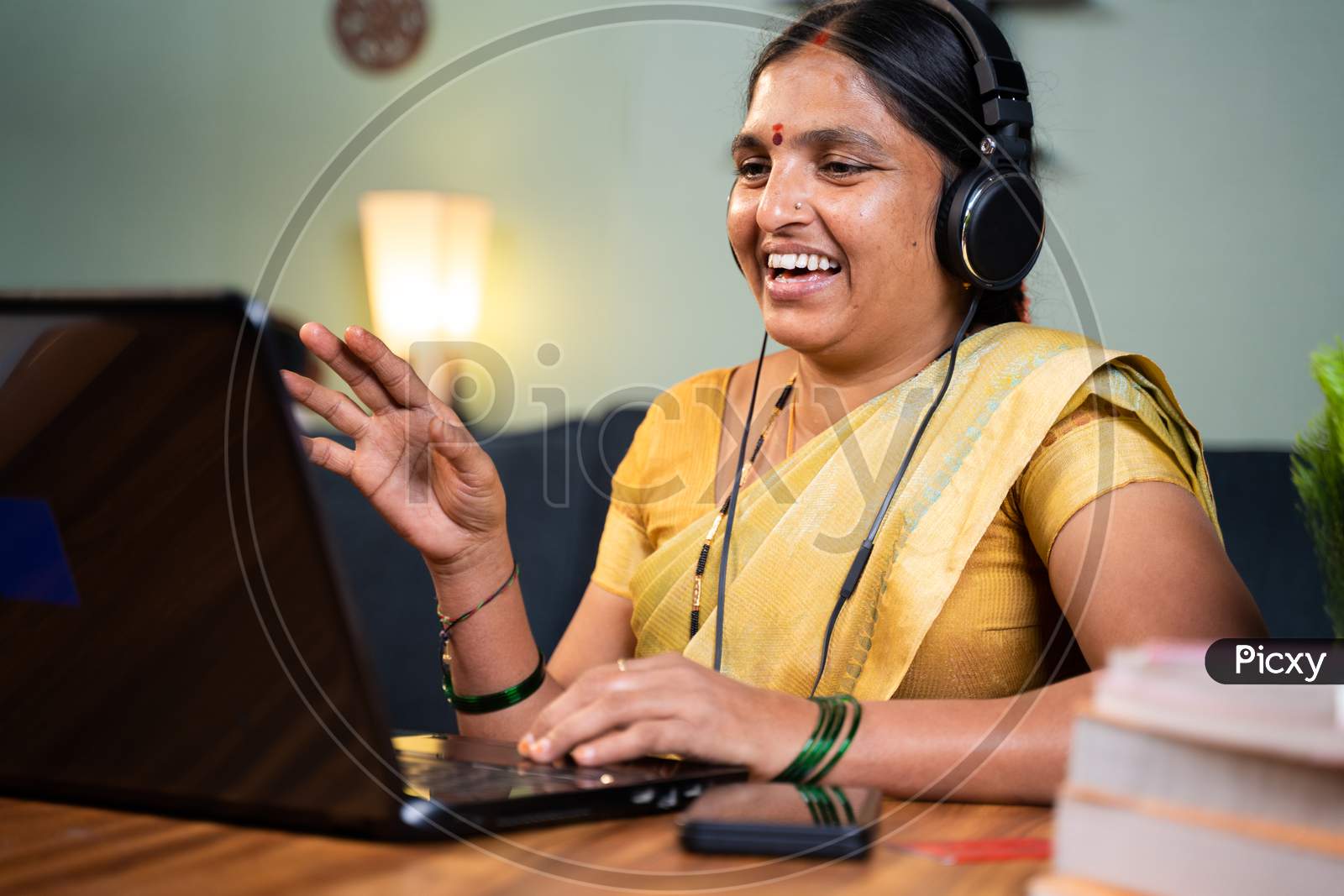 Happy Indian Woman With Headphones Busy Talking In Video Call On Laptop - Concept Of Online Chat, Distance Webinar, Video Conference During Work From Home