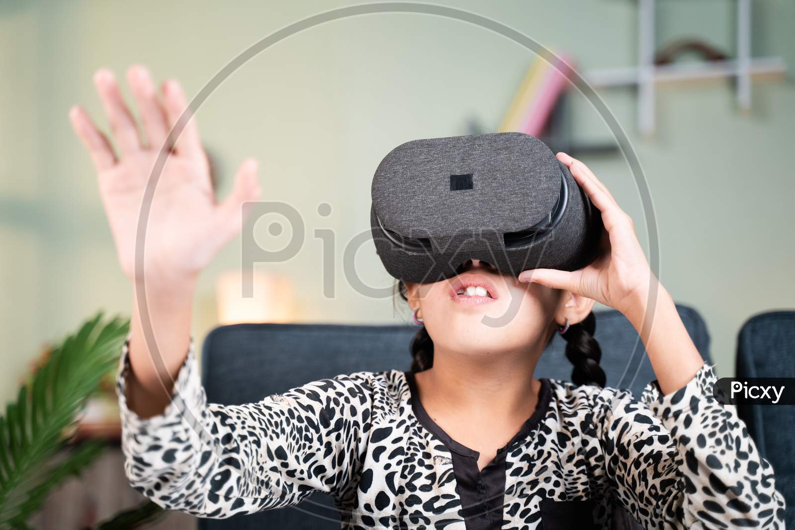 Young Girl Kid With Vr Or Virtual Reality Goggles Feeling Or Enjoying The 360 Degree Virtual Environment At Home - Concept Of Showing Modren Vr Technology In Modern Lifestyle.