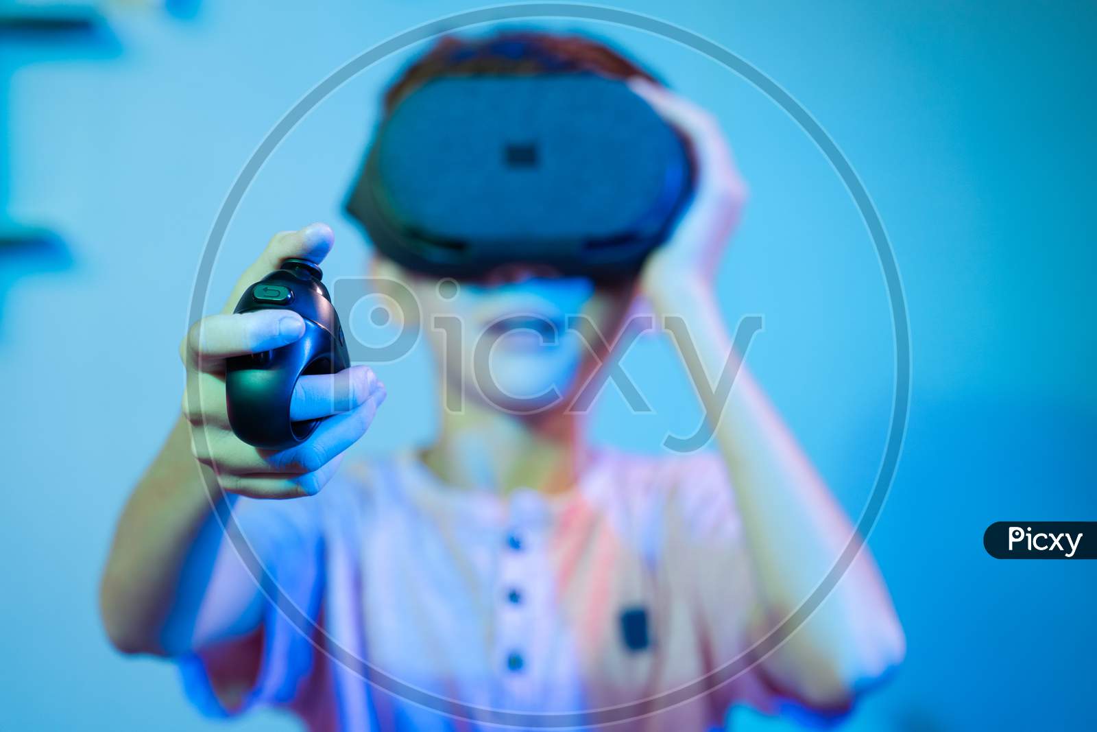 Selective Focus On Joystick, Young Kid Playing Video Game By Wearing Vr Or Virtual Reality Headset Using Game Pad Or Joystick.