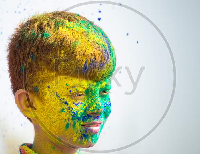 Head Shot Of Smiling Kid With Color Applied During Holi Festival Celebration With Copy Space