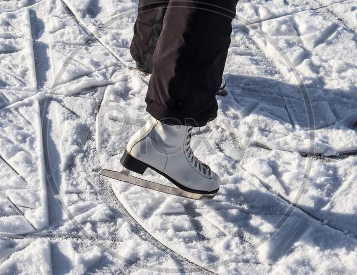 Close Up On Womans Feet Wearing Ice Skating Boots And Standing On Ice.