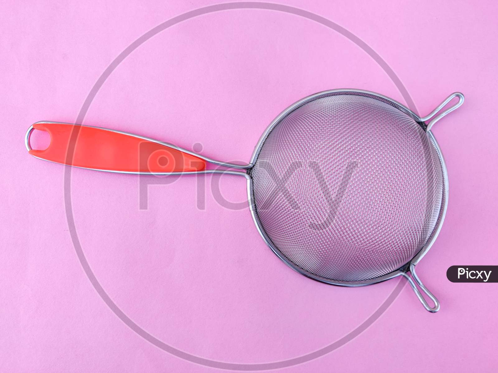 Top View Of Stainless Steel Soup & Juice Strainer Or Liquid Filter With Handle Isolated On Pink Background