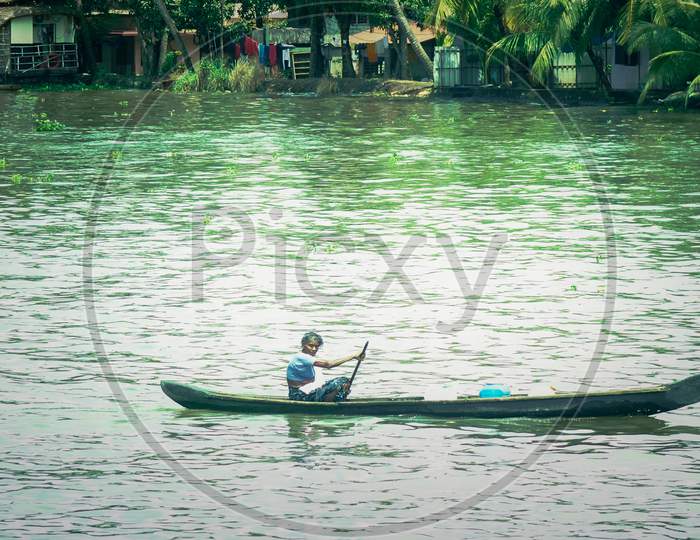 an old women traveling in a small boat in kerala alapuzha