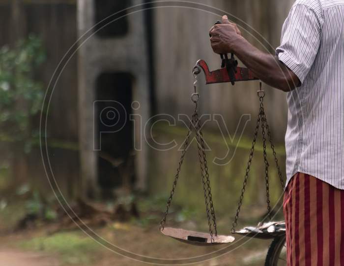 Fishermen Hand Holding A Scale, Balancing Fish And The Weight Close Up Photo, The Typical Way Of Measuring The Weight Of Fish In Major Parts Of Sri Lanka.