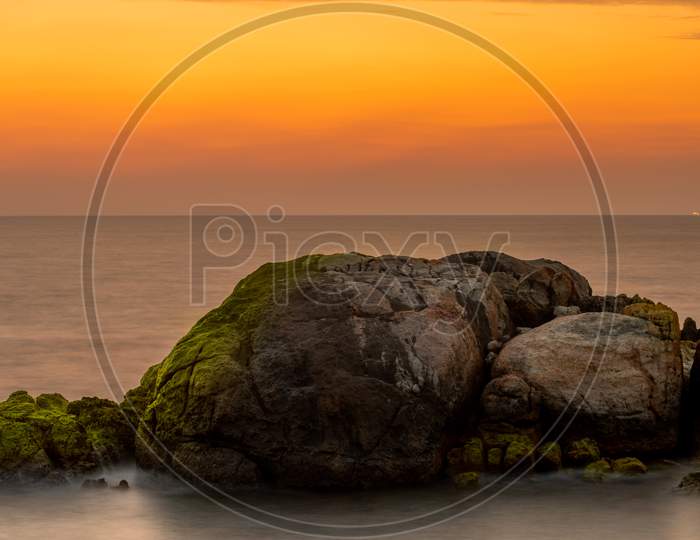 Long Exposure Golden Sunset In Galle Fort, Rocks, And Glowing Moss Creates Depth And Drama. Beautiful Compositional Rock Formation In The Foreground As The Sun Has Set On The Sea Horizon.