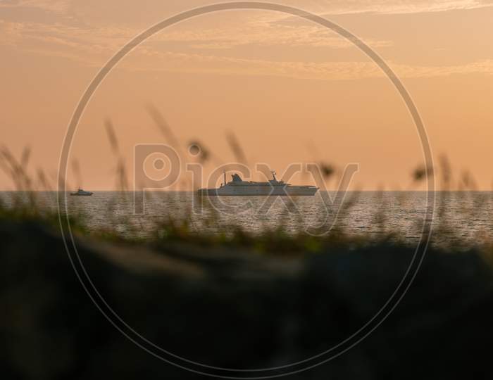 Ship Sails In The Horizon View Through The Grass Cover In The Beach Of Galle Evening Landscape Photograph.