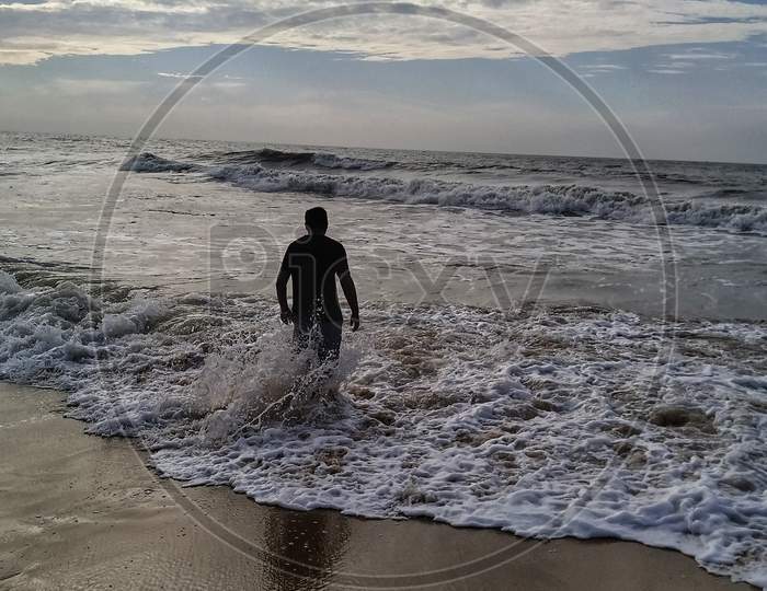 Young man enjoying the waves in the sea, Mahabalipuram Beach
