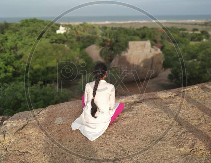 Young woman enjoying the view of the sea and nature from Olakkanesvara temple, Mahabalipuram