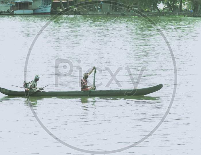 a two people rowing and fishing in a small boat