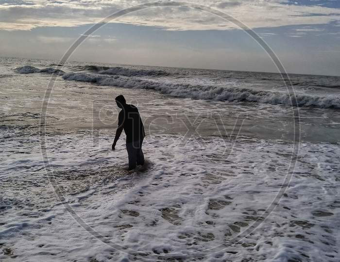 Young man enjoying the waves in the sea, Mahabalipuram Beach