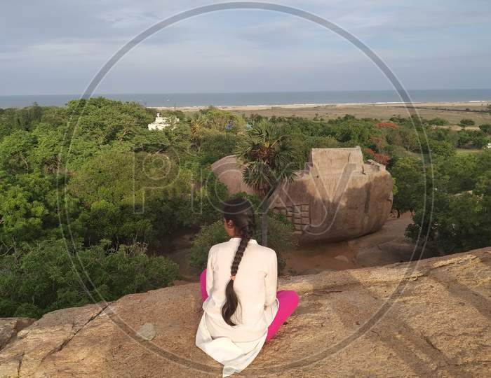 Young woman enjoying the view of the sea and nature from Olakkanesvara temple, Mahabalipuram