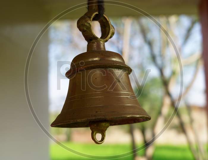 Selective Focus On Temple Ring With Blurred Background. Brass Temple Ghanta Or Bell For Sound Vibrations In Hindu Temple.