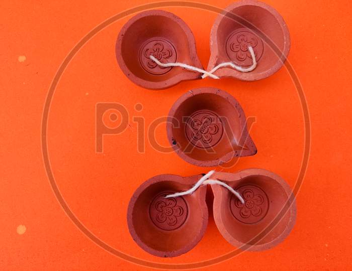 Top View Of Five Clay Lamps With Wick Isolated On Orange Background