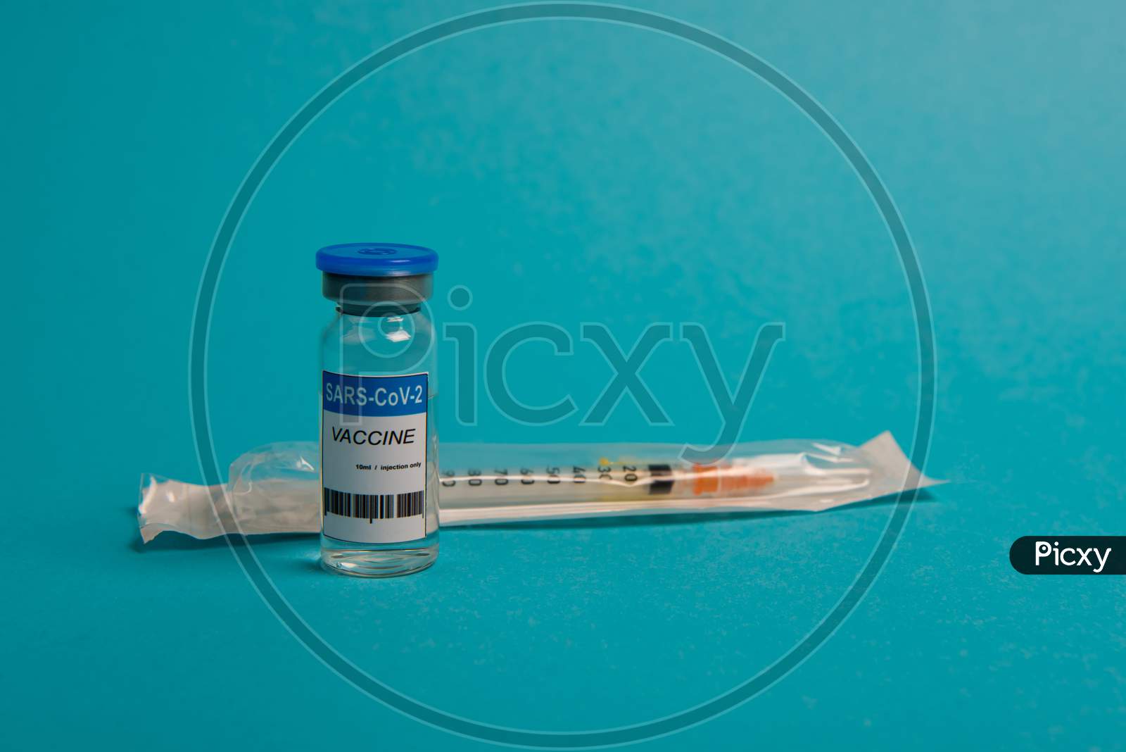 Covid-19 Coronavirus Vaccine Bottle And Syringe On Blue Background. Selective Focus.