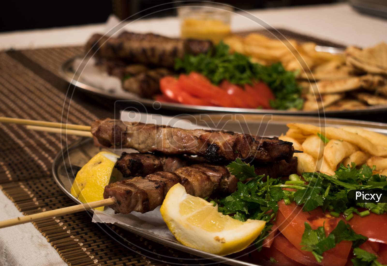 Fried Souvlaki, Traditional Lamp Kebab With Fresh Salad And Sauce In Plate On Wicker Surface.