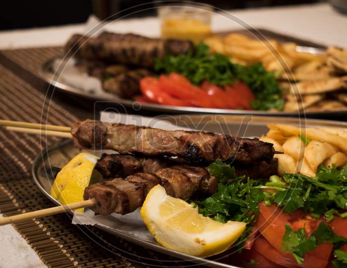 Fried Souvlaki, Traditional Lamp Kebab With Fresh Salad And Sauce In Plate On Wicker Surface.