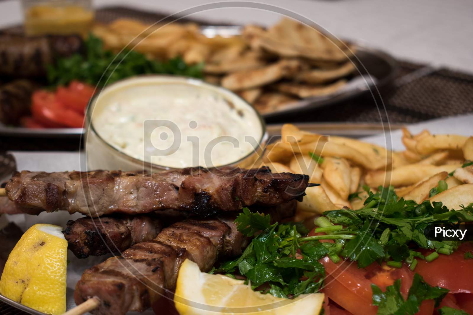 Fried Souvlaki With Greek Salad, Potatoes And Tzatziki Sauce In Plate