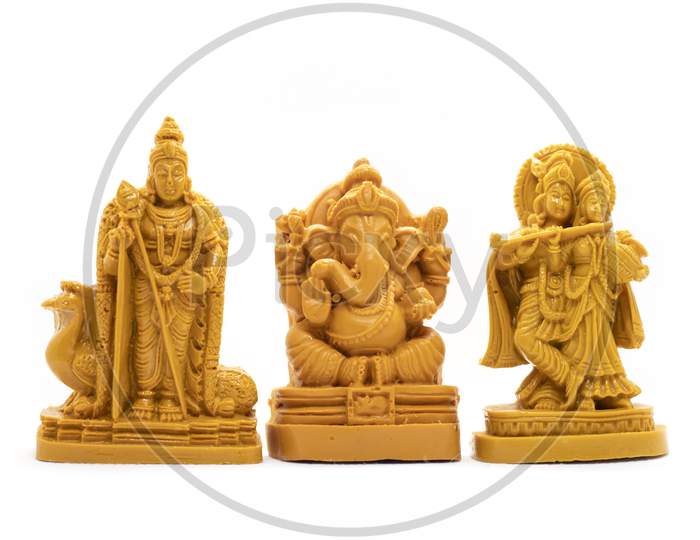 The Hand-Carved Wooden Idol Of Lord Murugan With Radha Krishna And Ganesha Is Isolated On A White Background