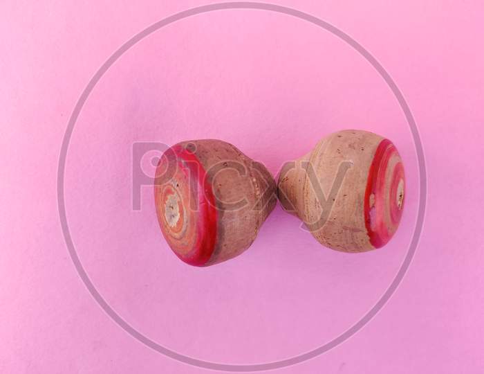 Top View Of Two Small Wooden Spinning Top Toys Isolated On Pink Background