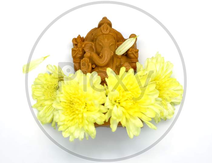 Ganesha Statue With Yellow Flowers Of Hindu God On White Background At The Top View