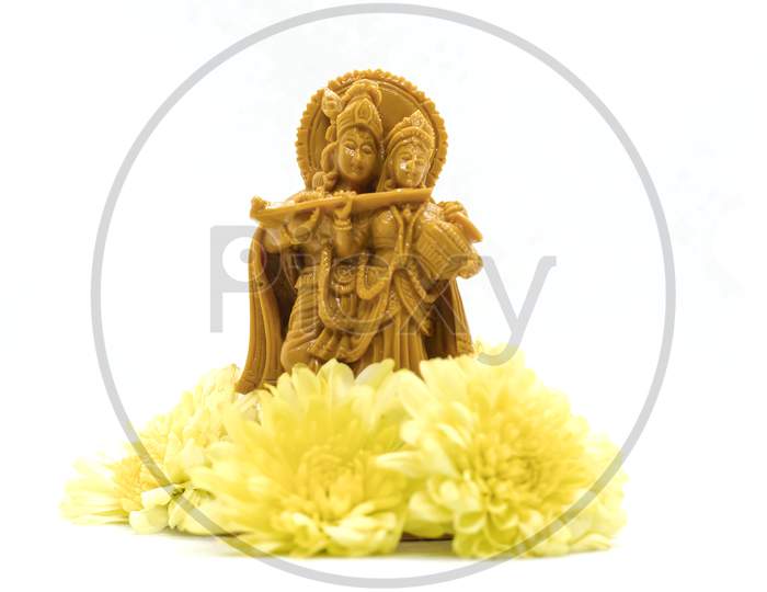 The Statue Of Radha Krishna With Flowers Is Isolated On A White Background
