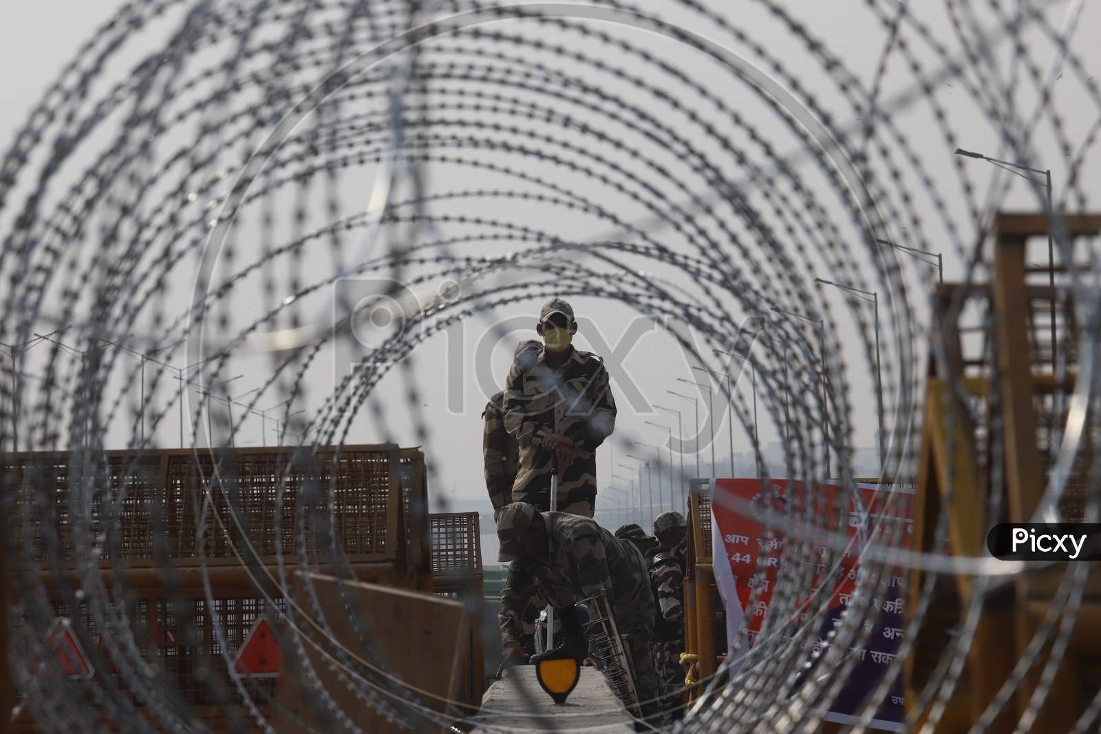 Barbed wires are seen on police barricades along a blocked highway as farmers continue their protest against the central government's recent agricultural reforms at Delhi-Uttar Pradesh border in Ghaziabad on February 2, 2021.