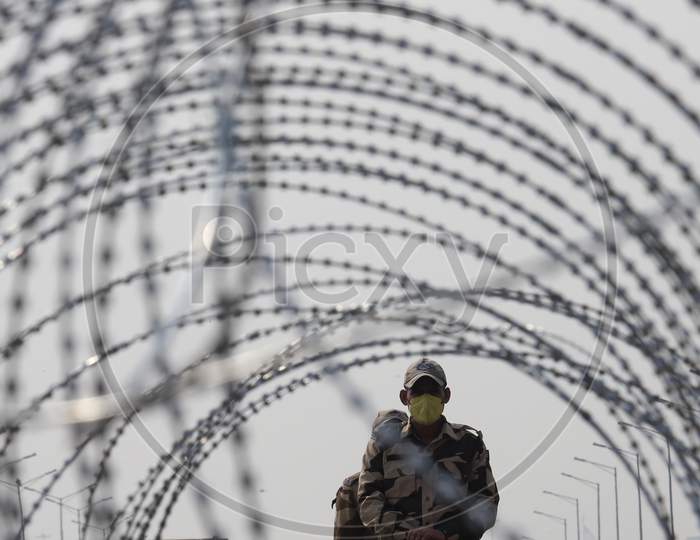 Barbed wires are seen on police barricades along a blocked highway as farmers continue their protest against the central government's recent agricultural reforms at Delhi-Uttar Pradesh border in Ghaziabad on February 2, 2021.