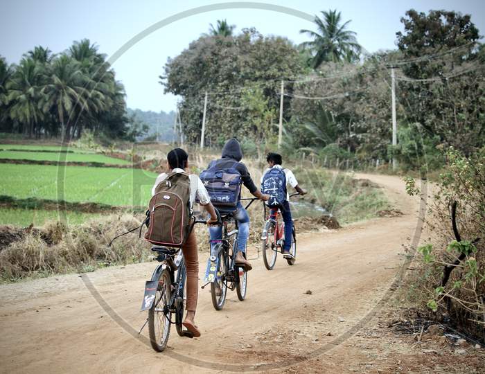 Village school kids riding bicycles.