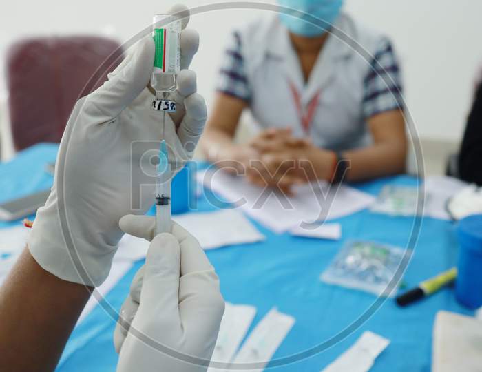 Gloved Hand Drawing Vaccine In A Syringe