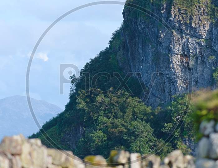 Rugged And Dramatic Cliff Landscape With Blurred Stone Wall Foreground