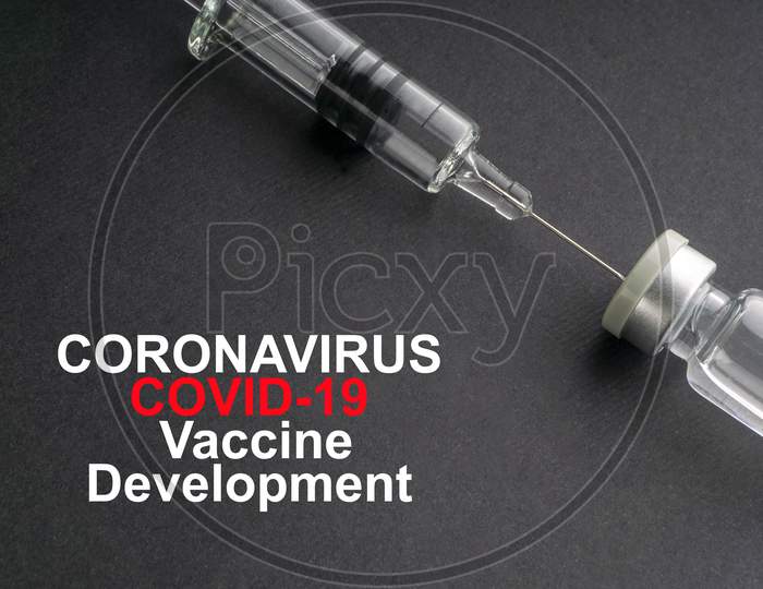 Coronavirus Covid-19 Vaccine Development Text With Syringe And Vials On Black Background