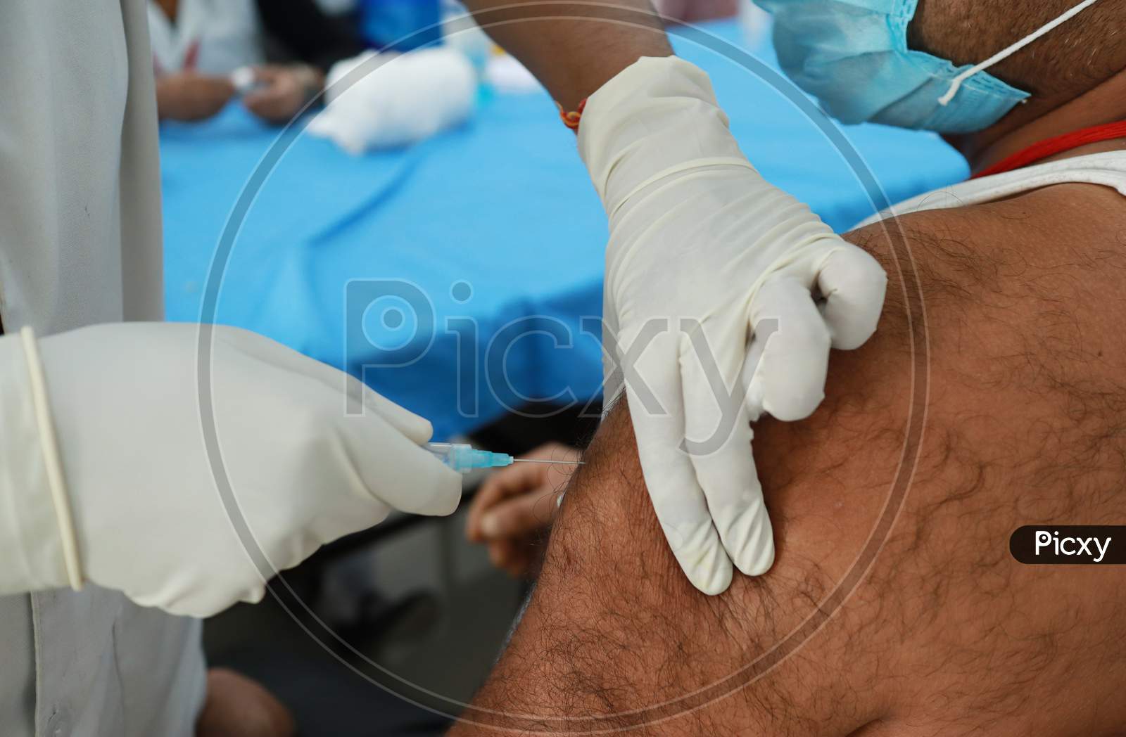 Gloved Hand Giving Injection In A Shoulder.Corona Virus Vaccination Concept.