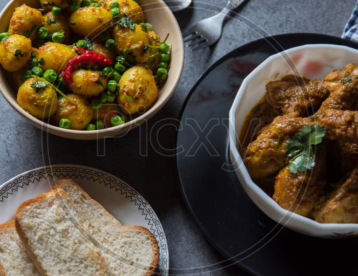 Spicy food ingredients chicken in gravy and dum aloo or masala potatoes cooked in Indian style.