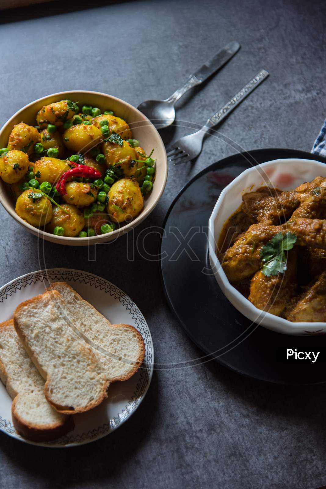 Spicy food ingredients chicken in gravy and dum aloo or masala potatoes cooked in Indian style.