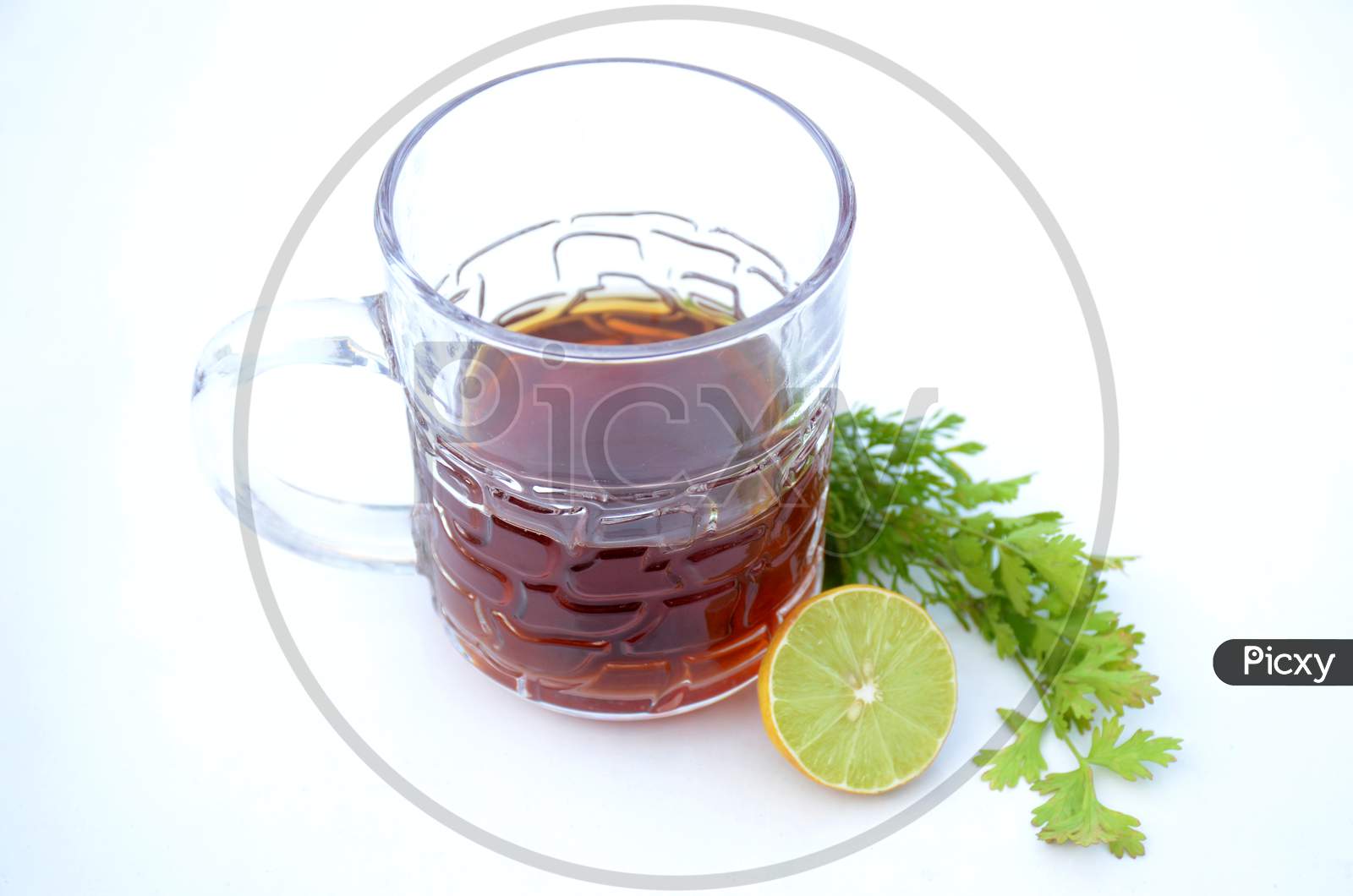 The Black Lemon Tea In The Glass Cup With Anise And Lemon On The White Background.