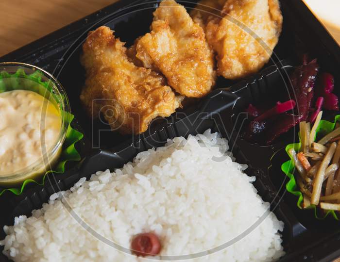 Delicious fresh rice with fried chicken with sauce in black plate