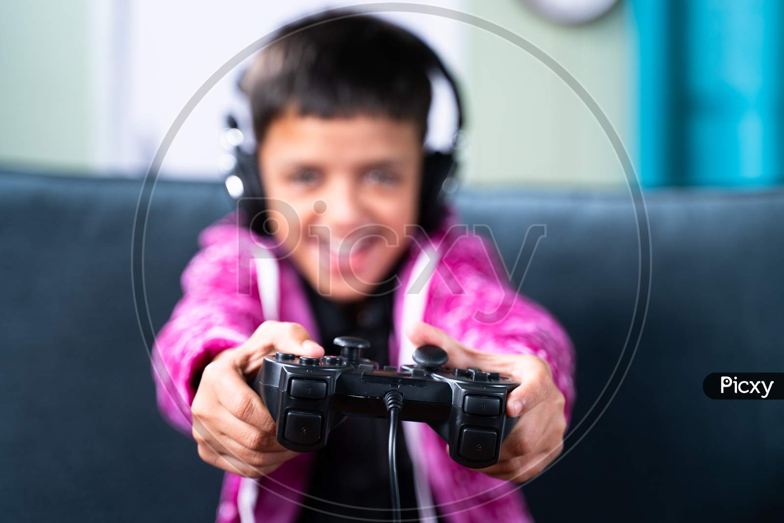 Close Up Selective Focus On Joystick, Kid Enjoying Videogame Using Gamepad At Home While Sitting On Sofa.